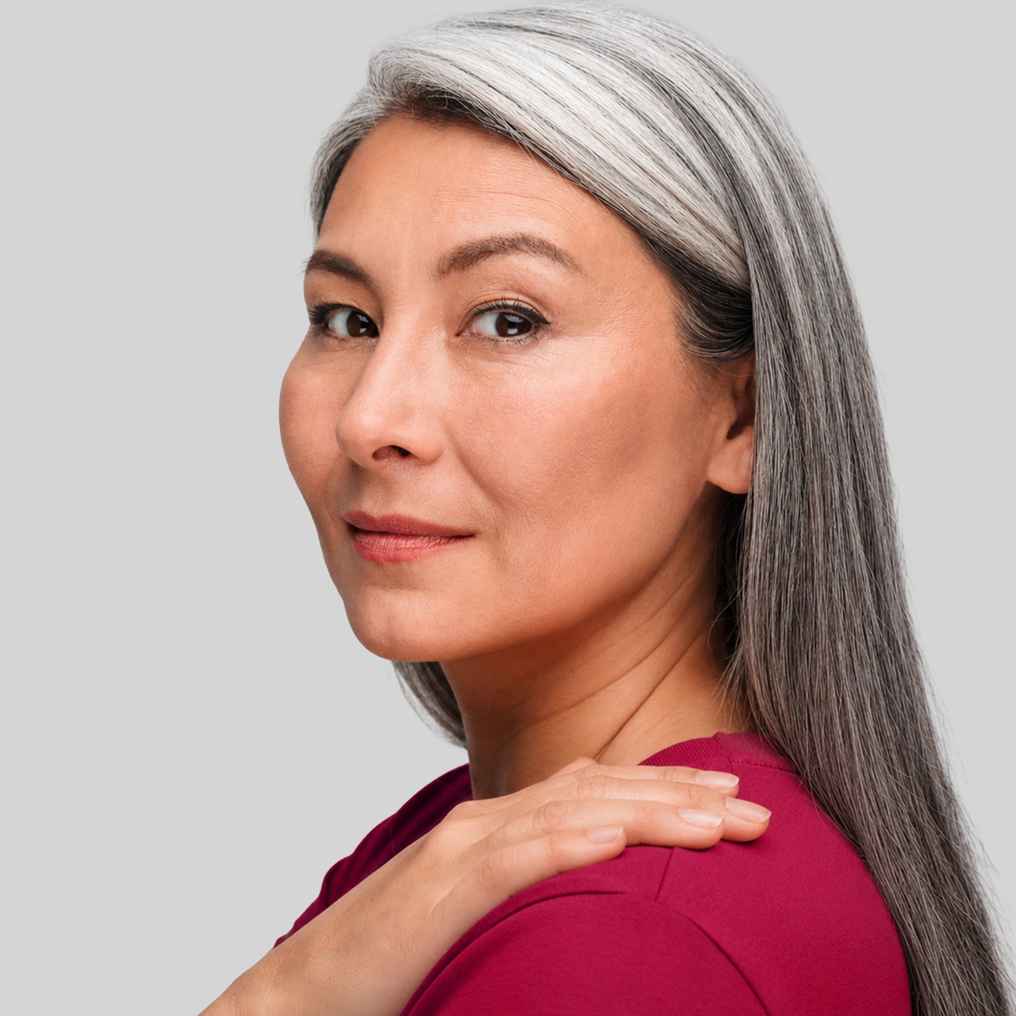 Primo piano di donna con chioma liscia e capelli grigi visibili