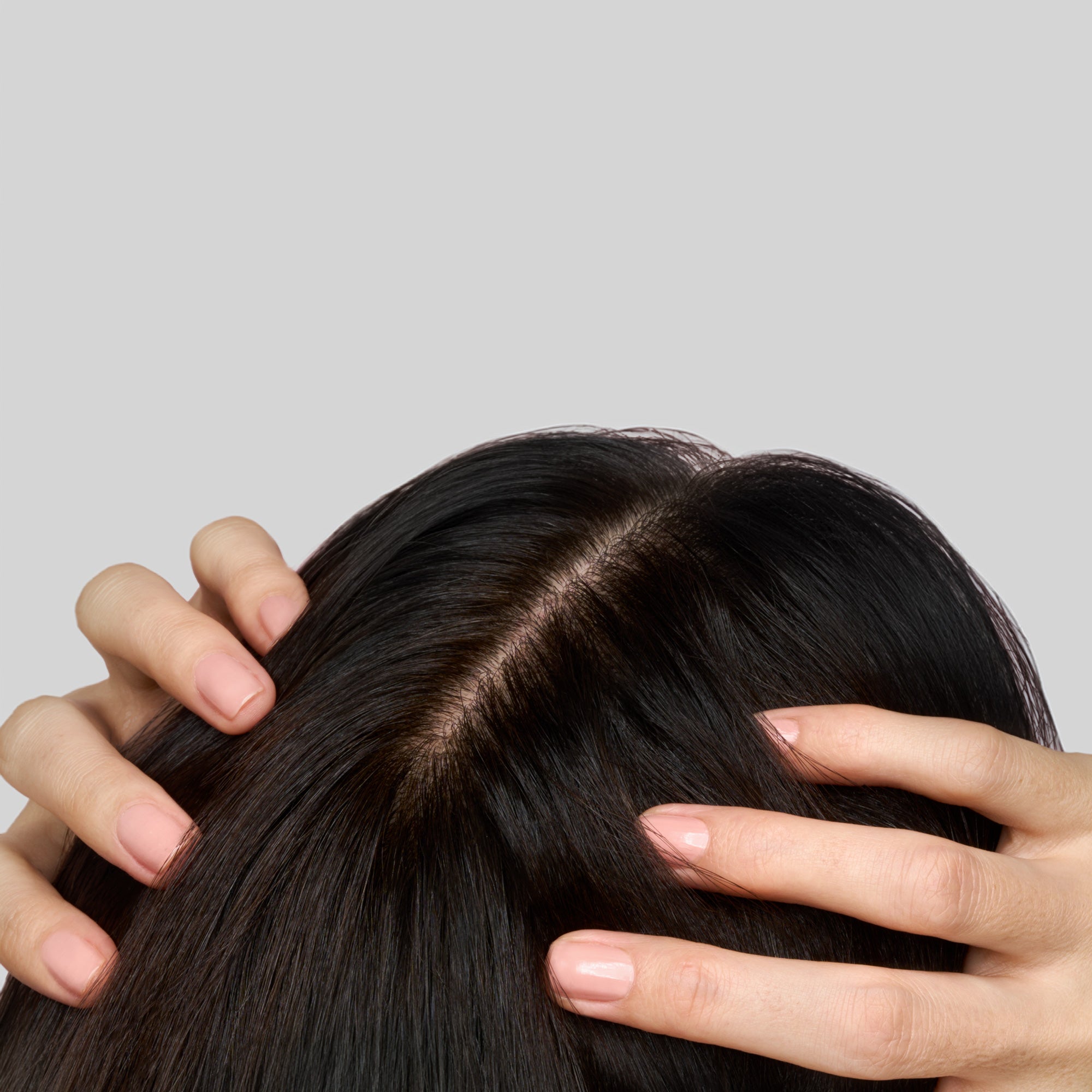 Vista dall’alto di donna che tocca i capelli lisci mostrando la radice