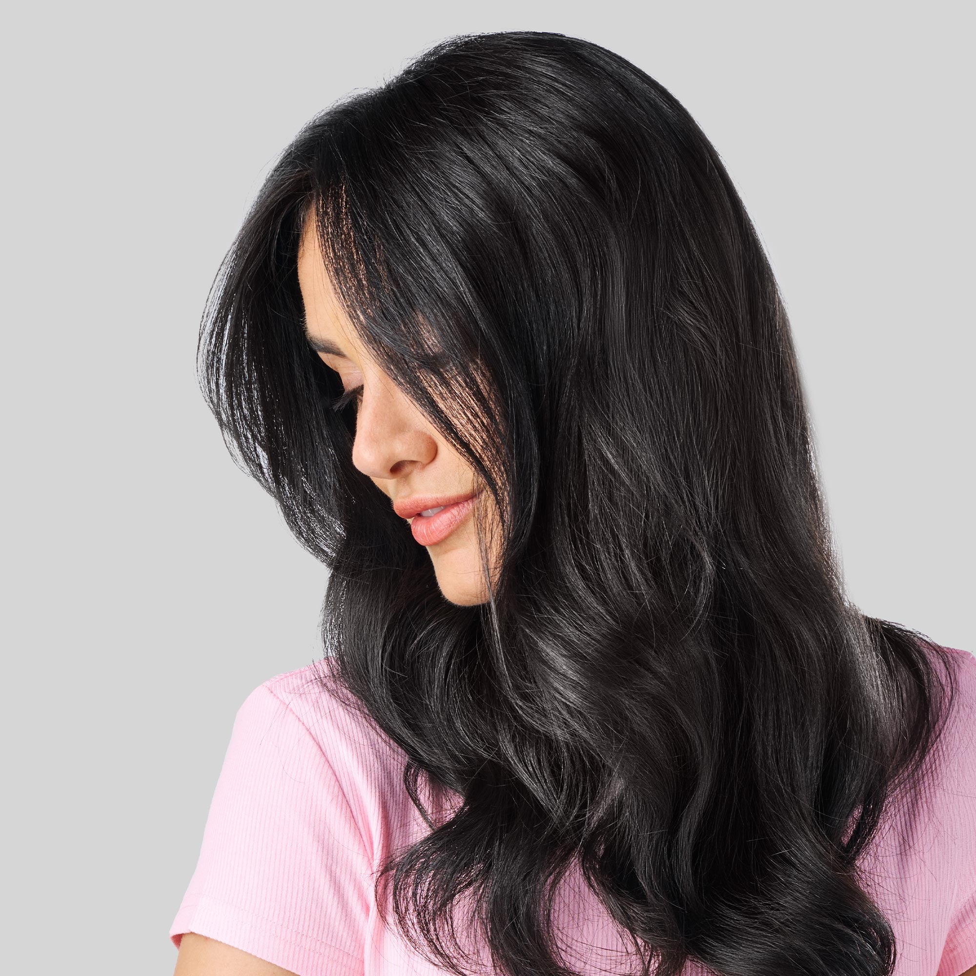 Donna con lunghi capelli neri, folti e luminosi, leggermente mossi sulle lunghezze.