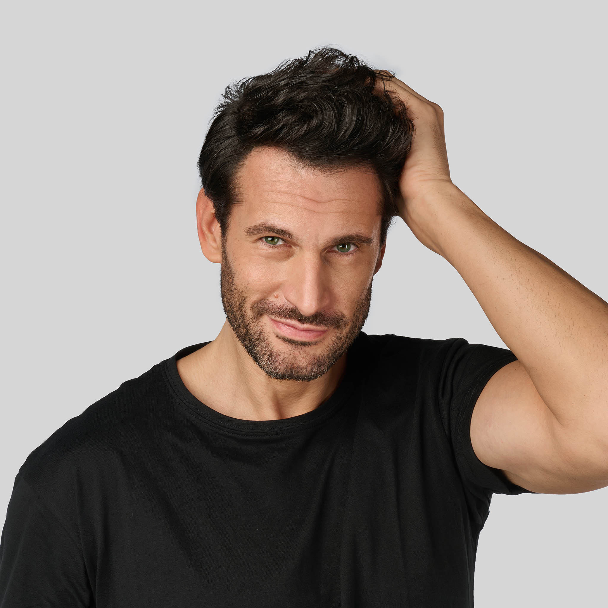 Uomo sorridente con la mano tra i capelli: il supporto ed i consigli degli esperti Bioscalin® per la salute della tua chioma