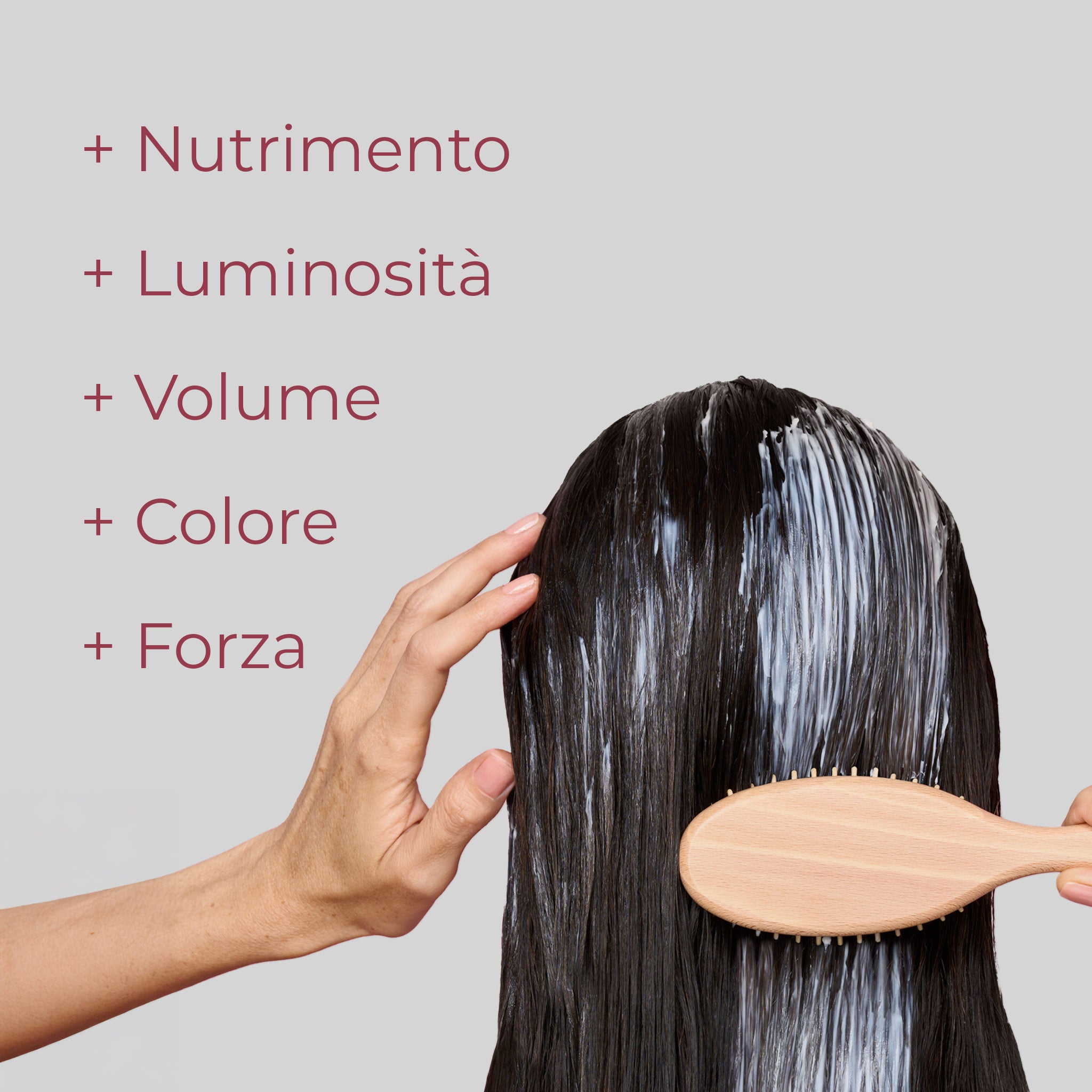 Ripresa posteriore di una ragazza che passa una spazzola tra i capelli per applicare il balsamo rinforzante Bioscalin® linea Menopausa