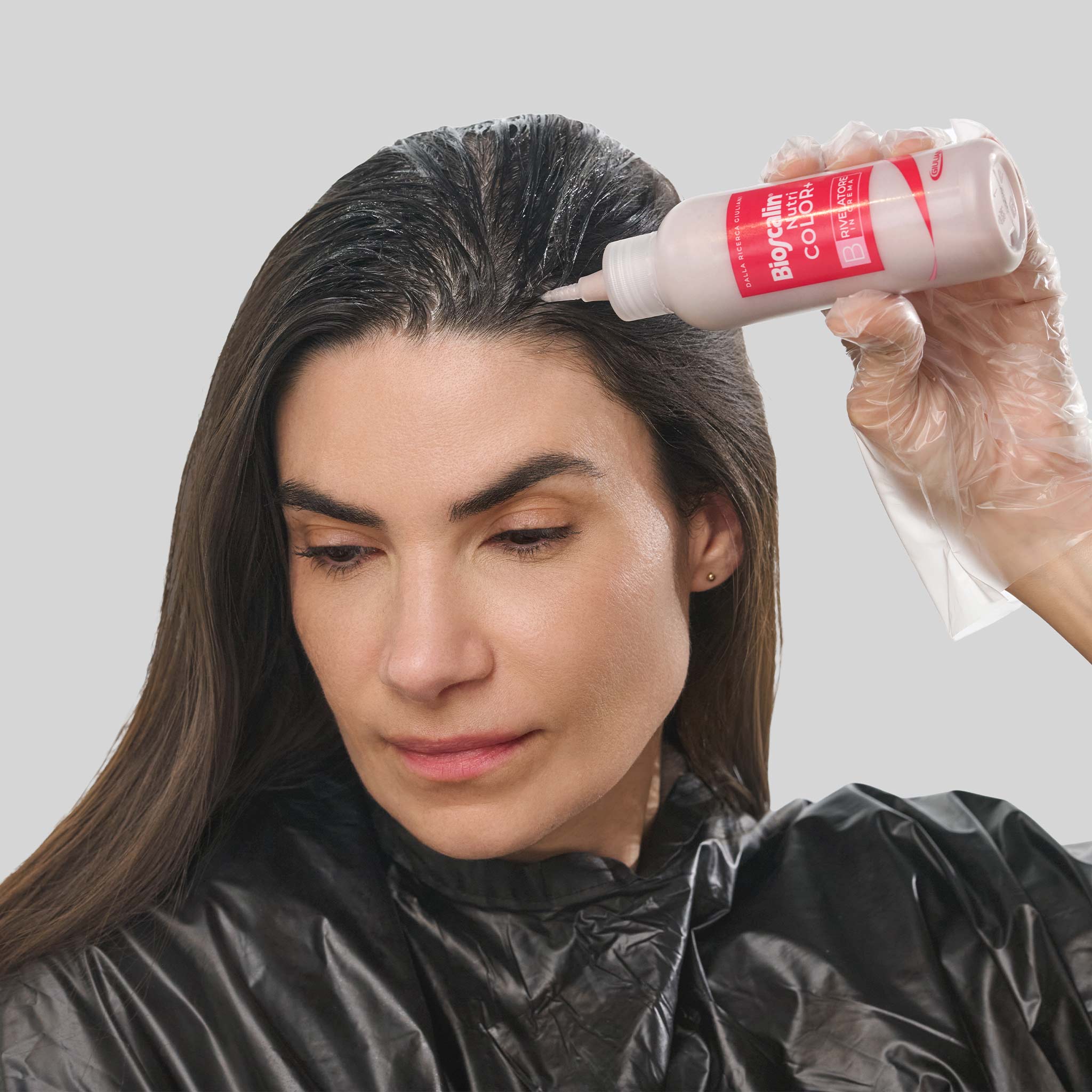 Donna che applica una tinta Bioscalin® NutriCOLOR+: stesura uniforme per un risultato professionale
