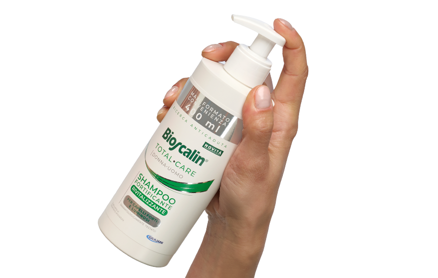 Mano che tiene il flacone di Shampoo Fortificante Rivitalizzante Bioscalin® in maxi formato 400ml