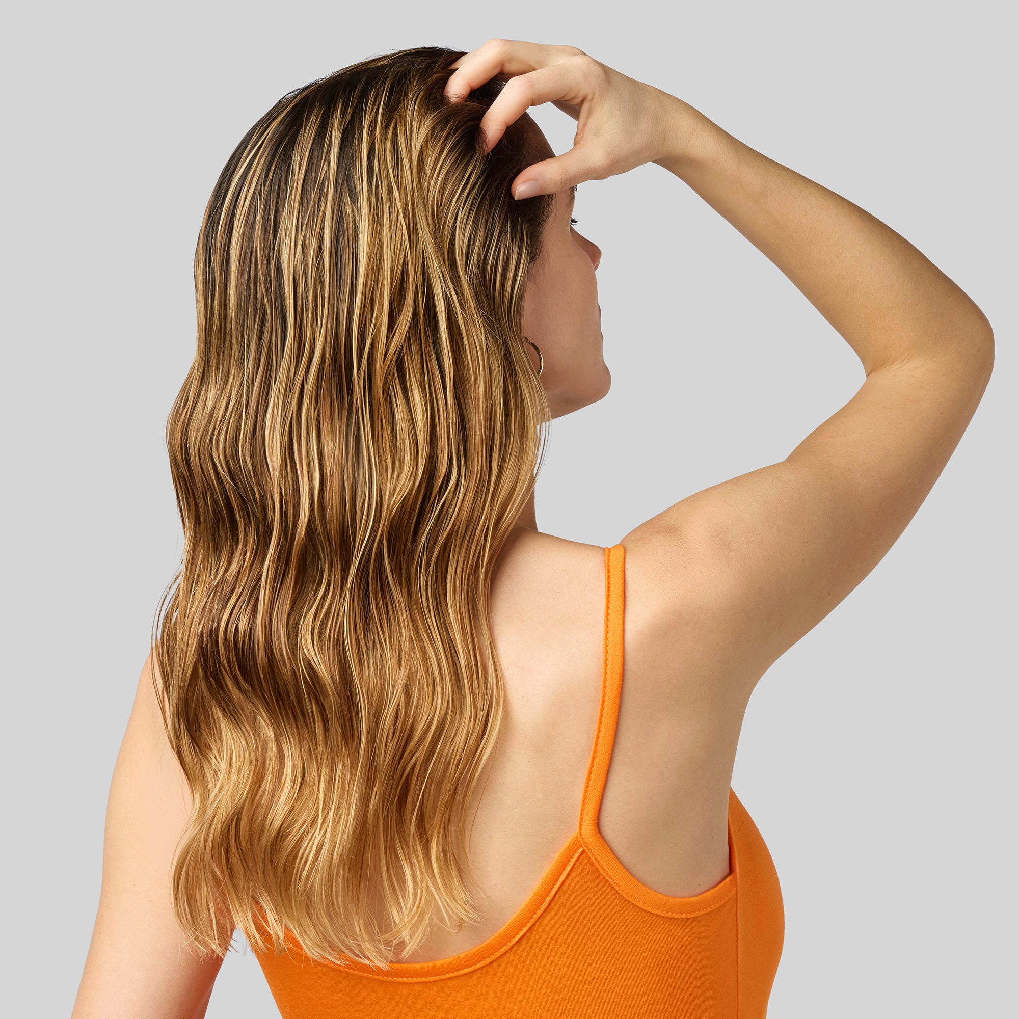 Capelli femminili bagnati, simbolo di protezione e cura della chioma durante l’esposizione solare con trattamenti Benessere Sole