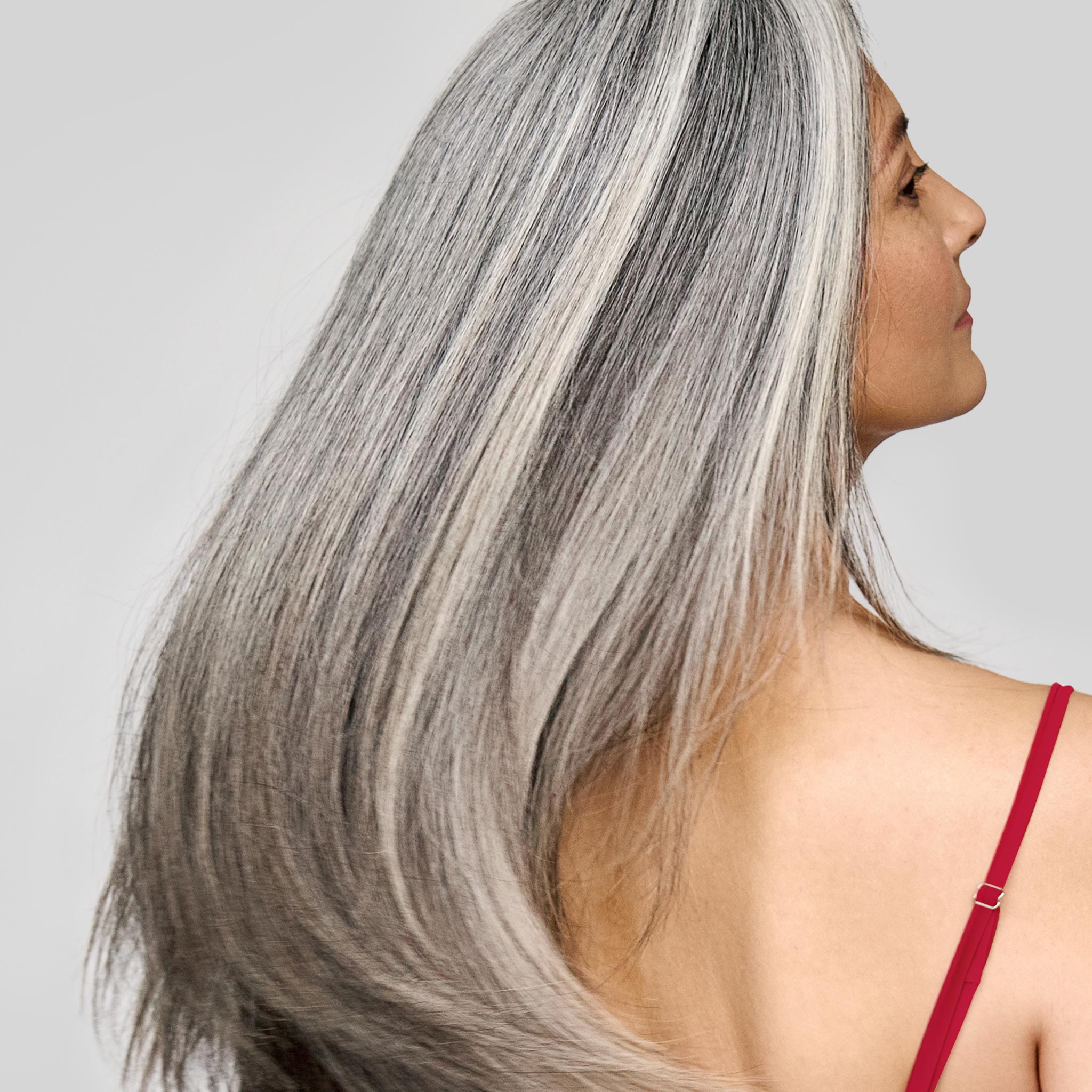 Donna con capelli castani luminosi e sani: colorazione Bioscalin® per un colore intenso e nutriente