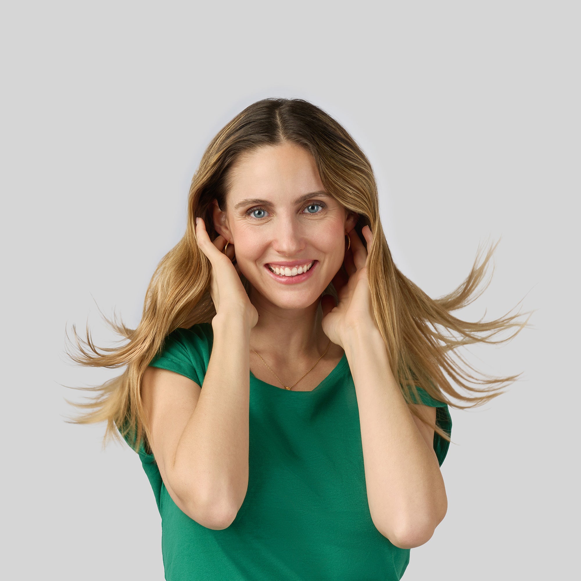 Donna con capelli lunghi e lisci sollevati leggermente dalle mani