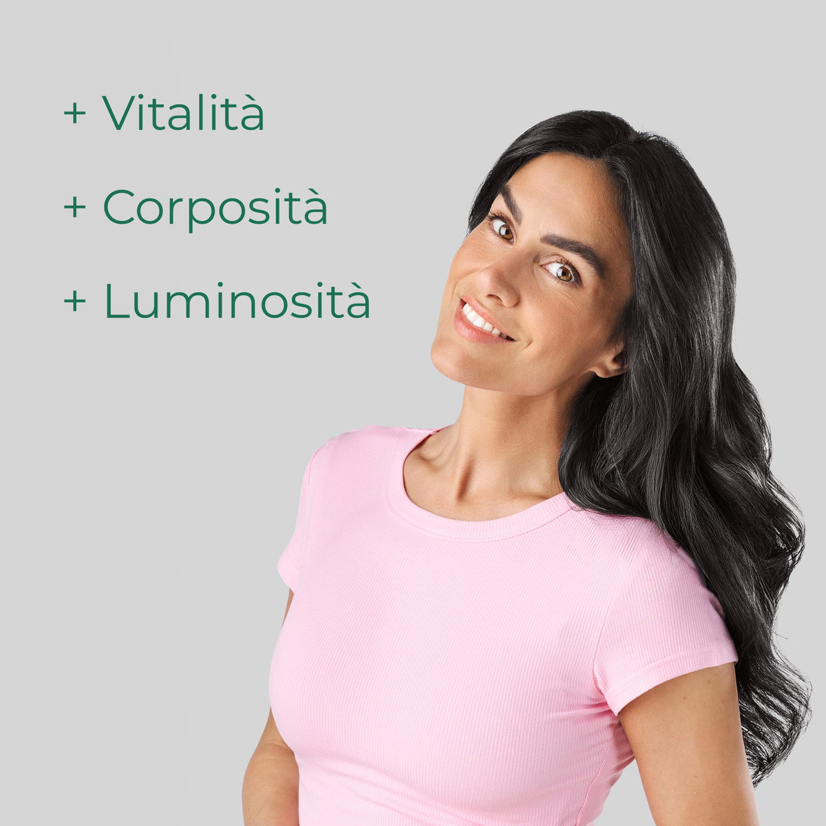 Donna sorridente con capelli lunghi e luminosi. Bioscalin® Post•Partum favorisce vitalità, corposità e luminosità dei capelli.