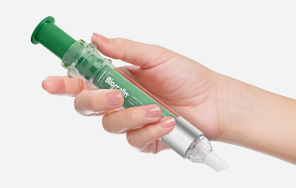 Mano che impugna l'applicatore Bioscalin® per un'applicazione mirata del trattamento sul cuoio capelluto
