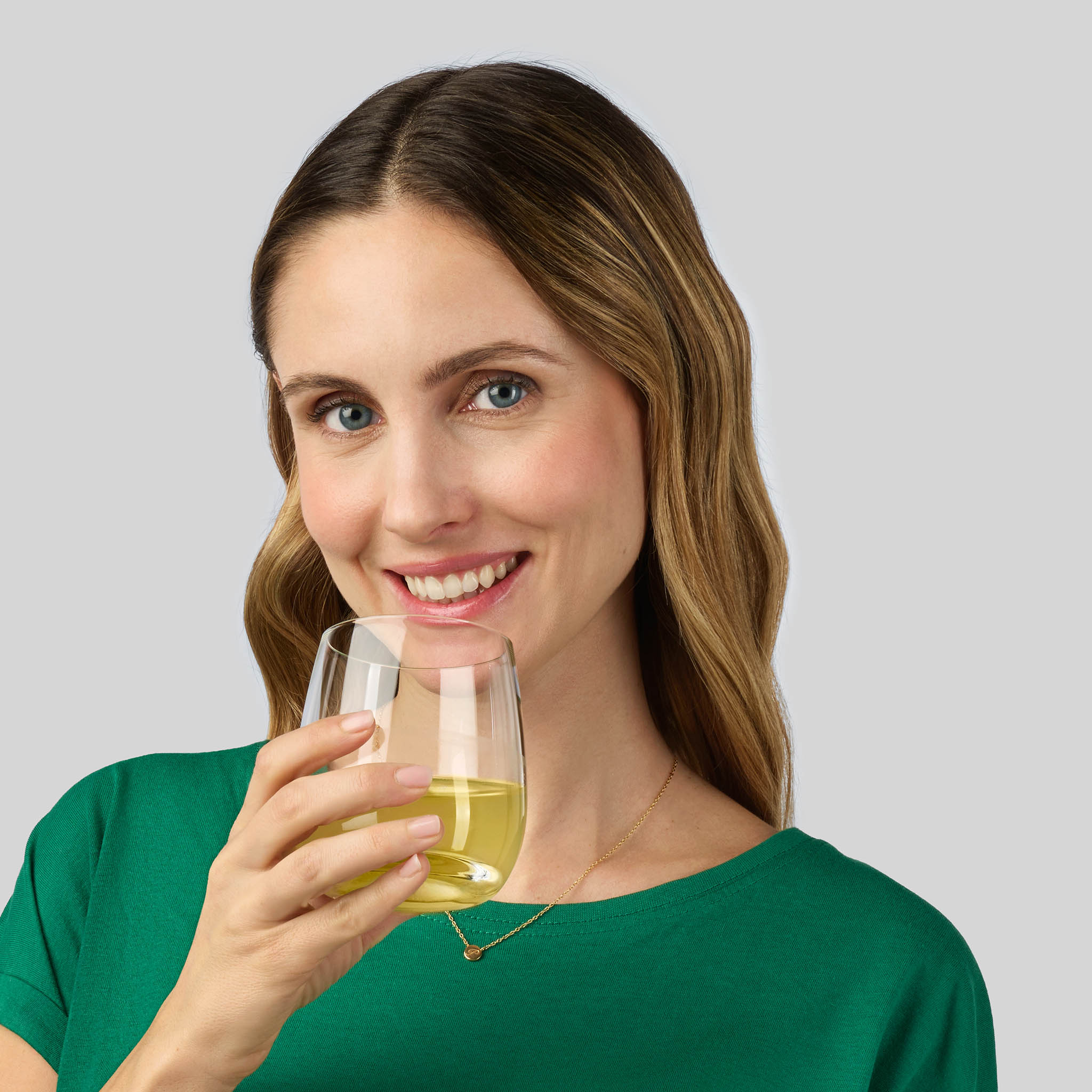 Donna che assume un integratore alimentare Bioscalin® in bustine sciolto in un bicchiere d'acqua