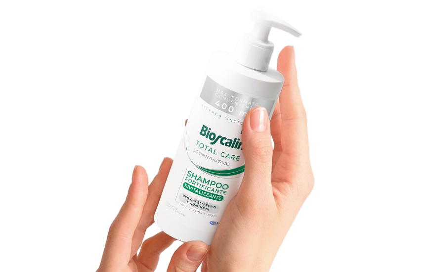Mano che tiene il flacone di Shampoo Fortificante Rivitalizzante Bioscalin® in maxi formato 400ml
